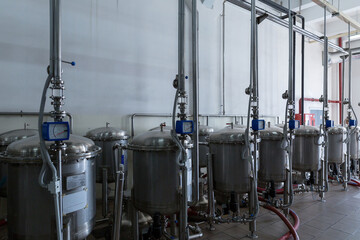 Stainless steel containers - filters are filled with high-quality granular activated carbon. The process of filtering of liquids at food industry facility of alcoholic or soft drinks production.