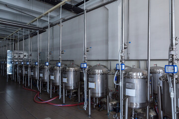 Stainless steel containers - filters are filled with high-quality granular activated carbon. The process of filtering of liquids at food industry facility of alcoholic or soft drinks production.
