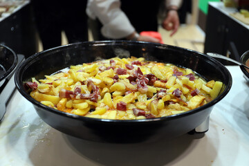 cacerola grande de patatas fritas y jamón serrano revuelto con huevos