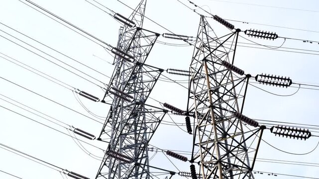 Two tall power lines are shown in the sky