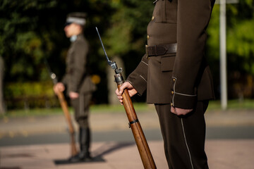Latvian honor guards standing in formal uniform holding ceremonial rifles with bayonets during...