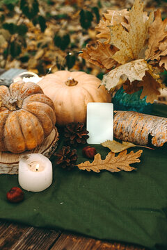 Atmospheric cozy autumn composition. Pumpkins, fall leaves, chestnut, candels. Thanksgiving day. Elegant rustic decor. Concept of cozy fall home atmosphere, aromatherapy. Copyspace.