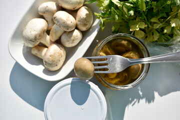 Marinated Mushroom on a Fork with Fresh Mushrooms and Herbs