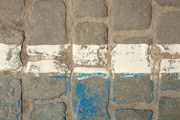White horizontal painted indistinct line on old granite cube. Texture, paint, surface, rough, cracked. Design space. Top view.