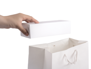 Delicate hand places pristine white gift box into elegant shopping bag, perfect for modern retail and thoughtful gifting occasions