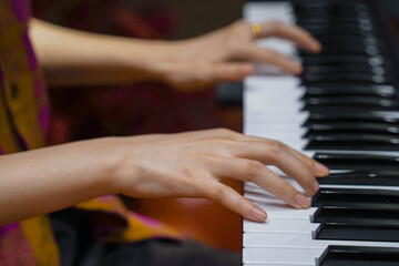 Obraz premium Close up of woman hands playing music on piano keys.