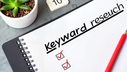 Notepad with keyword research checklist and succulent plant nearby  
