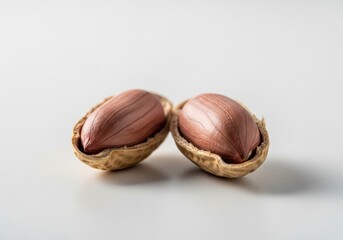 Two freshly cracked peanuts revealing their nutritious kernels on a clean white background