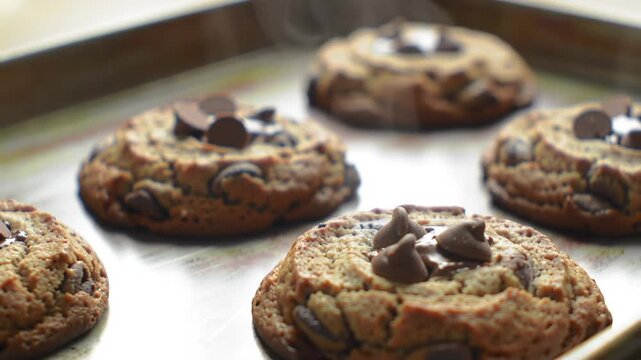 Freshly baked chocolate chip cookies on baking sheet overhead shot