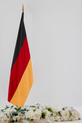 German flag and flowers on a white background with space for text.