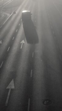 Morning Traffic on Multi-Lane Road in Foggy Weather. 4K video of cars driving away on a wide multi-lane road during a misty morning. Scene of urban traffic with dense fog or smog. Daily commute.