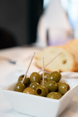 Green Olives and Bread on Restaurant Table