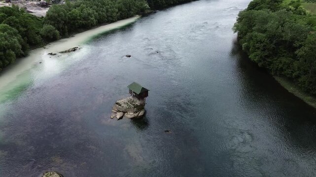 Famous Drina River house on a rock near Bajina Basta, Serbia, surrounded by water and forested mountains. Unique landmark and popular tourist attraction. Vertical aerial 4k footage