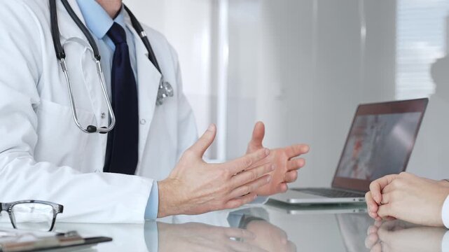 Consulting doctor explaining treatment or diagnosis to patient during medical appointment in clinic office. Medicine, healthcare and science concept
