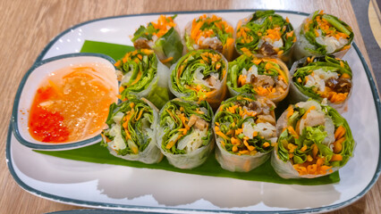 Fresh vegetable spring rolls with dipping sauce on a plate for appetizer
