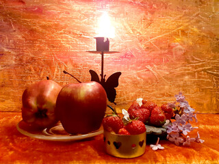 Red apples, strawberries, fruits, food. Lilac flowers. Evening romantic still life on a red background, candle in a candlestick. Romance, flowers, elegance, flair. Antique brass items