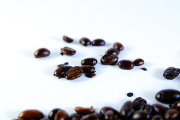 Freshly roasted coffee beans scattered on white background