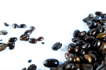 Rich roasted coffee beans spilling across a clean white surface, perfect for cafe menus, branding, or a vibrant morning start design element