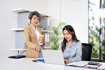  Professional mature business woman manager explaining  solutions helping young employee at work....