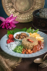 Beautifully arranged Thai shrimp paste fried rice, known as Khao Kluk Kapi, served with traditional side ingredients such as sweet pork, sliced omelet, red chili, shallots, dried shrimp, green beans, 