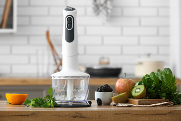 Blender and different fruits on table in kitchen