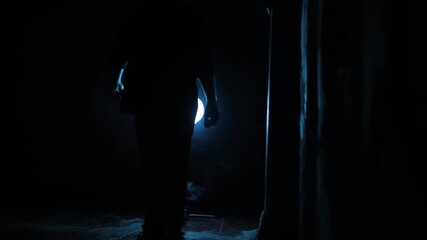 Silhouette of a young man walking alone in a dark gothic atmosphere with mysterious shadows and dramatic lighting creating a haunting cinematic mood and emotional visual concept
