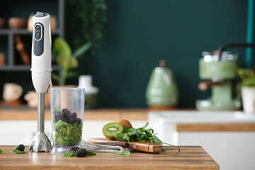 Modern blender and ingredients on table in kitchen