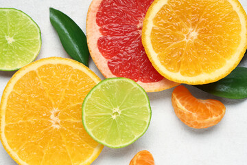 Slices of tasty citrus fruits on white background, closeup