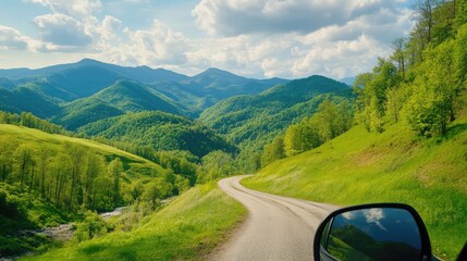 Calm nature drive shown through car mirror, green mountain slopes and peaceful rural roads