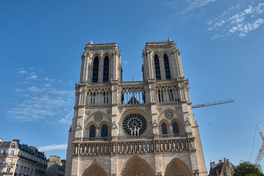 Notre Dame Cathedral in Paris with Gothic architectural details and a restoration crane visible on the facade