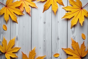 Autumn leaves on a white wooden background with copy space.