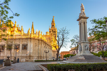Fototapeta premium Seville cathedral with Giralda tower and Monument of Immaculate Conception on Triumph square, Seville, Spain
