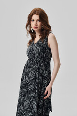 Fototapeta premium A girl model in stylish clothes poses on a gray background.