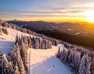 Aerial view of a snow-covered ski slope at sunset, with mountain views