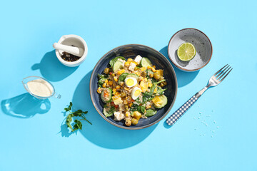 Healthy quinoa bowl with vegetables on blue background