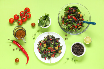 Plate with healthy quinoa salad and ingredients on green background
