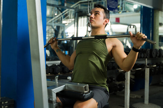 Young man doing lat pulldown exercise in gym