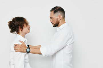 Professional businessman interacts with a colleague in a calm, supportive moment against a clean white background, showcasing confidence, focus, and teamwork.