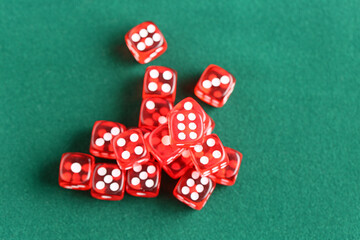 Red game dices on green background, closeup