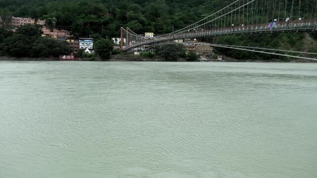 View of the Ganges (Ganga) River from Rishikesh, Uttarakhand, India | Ram Jhula the suspension bridge is also seen