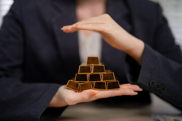 Business adult hands protect pyramid gold bars symbolizing financial security long term investment...