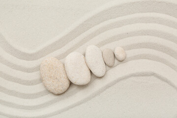 Composition with spa stones and lines on sand as background, closeup. Zen concept