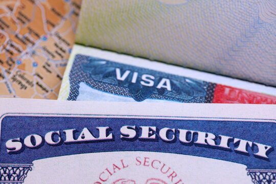 The American visa in a blurred passport page background and social security number personal document. SSN - social security number for live in USA