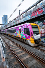 Fototapeta premium Close up, Train crossing urban bridge with graffiti walls