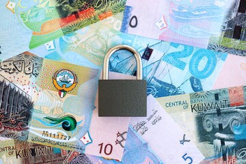 Kuwaiti dinar currency money bills and padlock close up. The concept of sanctions and financial...