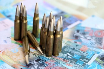 Kuwaiti dinar currency money bills and rifle bullets close up. The concept of warfare and gun...