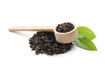 Wooden scoop with dry black tea and leaves on white background