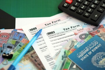 Kuwaiti dinar money bills and calculator with tax form on flag close up. Taxation and accounting...