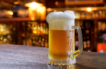 mugs of beer in a bar on wooden counter