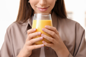 Young woman holding glass of tasty turmeric drink on white background, closeup